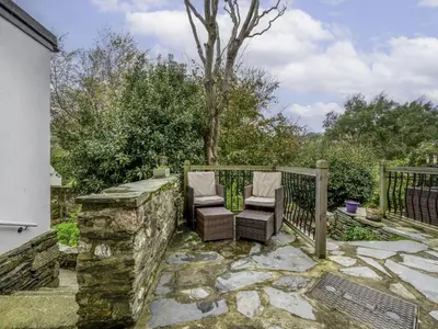 a patio with two chairs and a fence at Holiday Home Cherry Orchards by Interhome in Mevagissey