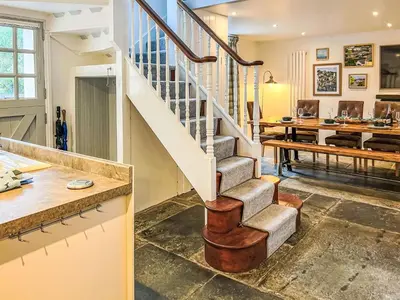 a staircase in a living room with a table at Holiday Home Cherry Orchards by Interhome in Mevagissey
