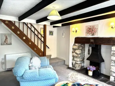 a living room with two chairs and a fireplace at Holiday Home Rosehip Cottage by Interhome in Pentewan