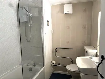 a bathroom with a shower and a toilet and a sink at Holiday Home Rosehip Cottage by Interhome in Pentewan