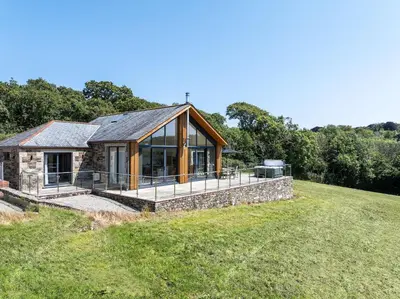 a stone house with a large glass extension at Callestock Vean in Truro