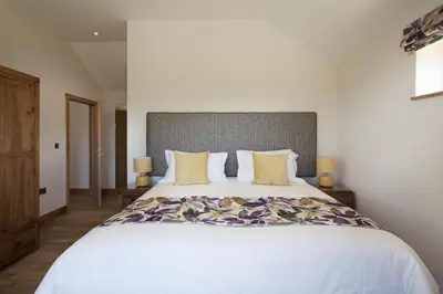 a bedroom with a large white bed with yellow pillows at Callestock Vean in Truro