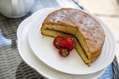 a piece of cake on a white plate with strawberries at Callestock Vean in Truro