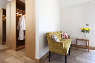 a room with a chair and a closet at Callestock Vean in Truro