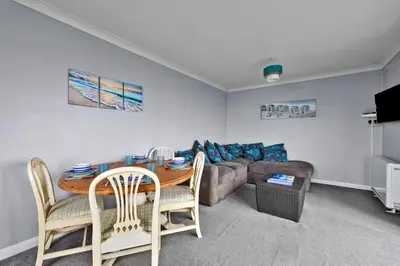 a living room with a table and a couch at Finest Retreats - Sea Thrift at Widemouth Bay in Widemouth Bay