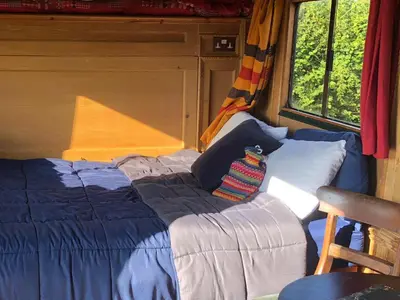 a bed in the back of a room with a window at Rosies in Liskeard