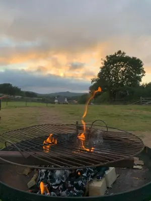 a grill with a fire in a field at Rosies in Liskeard