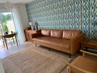a living room with a brown leather couch and a table at 2 Bed-Sleeps 4-Parking-Pets-10 min walk to Beach in Falmouth