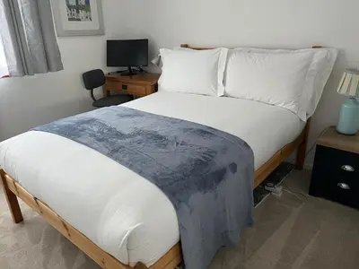 a bed in a room with a desk and a bed sidx sidx sidx at 2 Bed-Sleeps 4-Parking-Pets-10 min walk to Beach in Falmouth