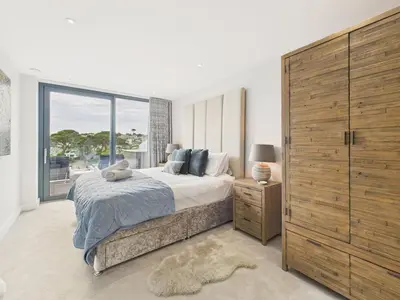 a bedroom with a large bed and a large window at Skydeck at The Liner – Stylish 2-Bed / 2-Bath Top Floor with Panoramic Sea Views in Falmouth