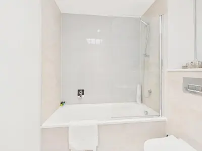 a white bathroom with a tub and a toilet at Skydeck at The Liner – Stylish 2-Bed / 2-Bath Top Floor with Panoramic Sea Views in Falmouth