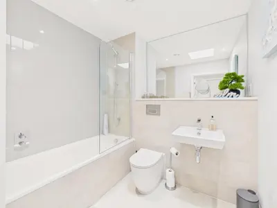 a white bathroom with a toilet and a sink at Skydeck at The Liner – Stylish 2-Bed / 2-Bath Top Floor with Panoramic Sea Views in Falmouth