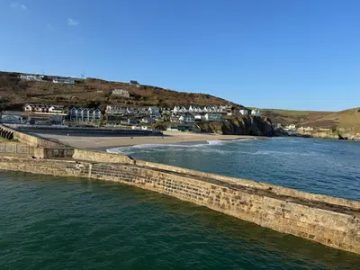 a body of water with a beach and houses at Harbour Edge in Portreath
