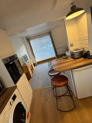a kitchen with a washer and dryer in a room at Harbour Edge in Portreath