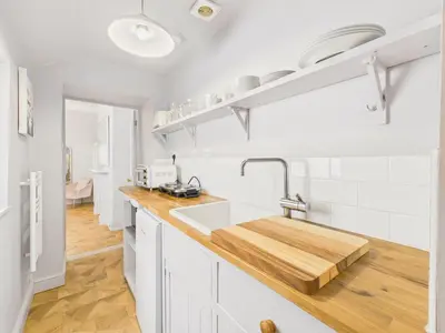 a kitchen with white cabinets and a sink at Cosy Coastal Falmouth Studio with Free parking & WiFi in Falmouth