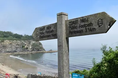 a sign at the beach with a view of the ocean at Sea Spray in St Austell