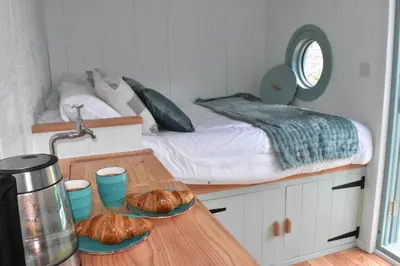 a bedroom with a bed and two loaves of bread on a table at Sea Spray in St Austell