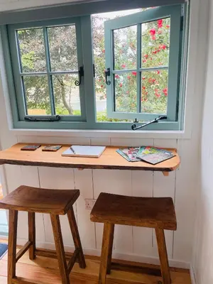 a desk with two stools in front of a window at Sea Spray in St Austell