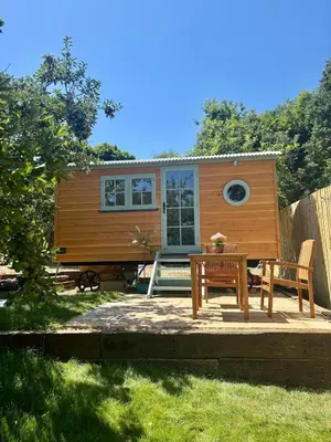 a tiny house with a table and chairs in a yard at Sea Spray in St Austell