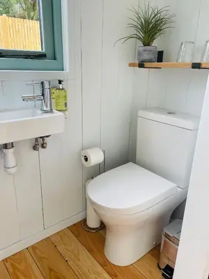 a small bathroom with a toilet and a sink at Sea Spray in St Austell