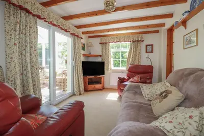 a living room with a couch and a television at Temple House in Truro
