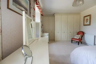a bedroom with a white bed and a red chair at Temple House in Truro