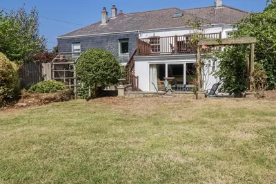 a house with a deck and a yard at Temple House in Truro