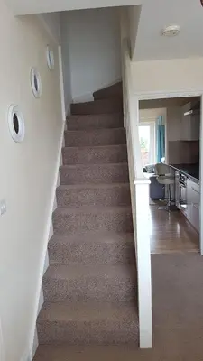 a stairway in a house with a kitchen and a kitchen at Tolcarne Reach in Newquay
