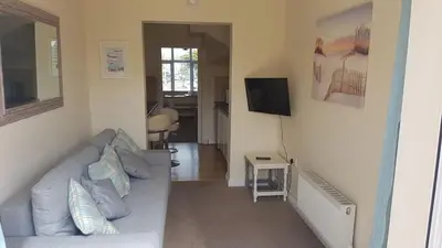 a living room with a couch and a flat screen tv at Tolcarne Reach in Newquay