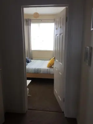 a small bedroom with a bed and a window at Tolcarne Reach in Newquay