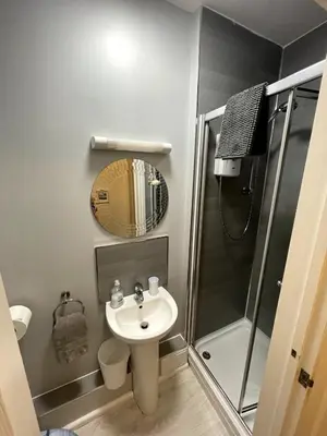 a small bathroom with a sink and a shower at Tolcarne Reach in Newquay