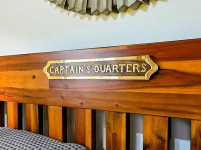a sign on the top of a wooden crib at The Captains Quarters in Porthtowan