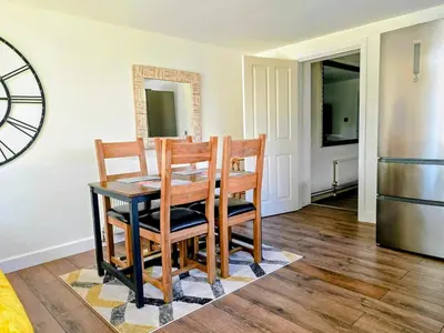 a kitchen with a table and chairs and a refrigerator at The Captains Quarters in Porthtowan