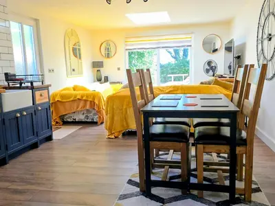 a room with a table and chairs and a bedroom at The Captains Quarters in Porthtowan