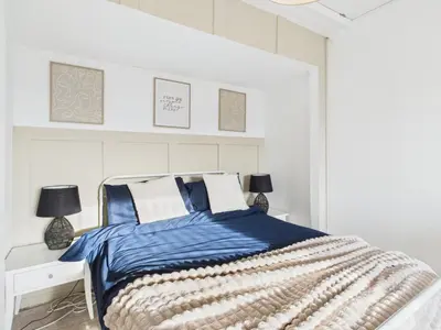 a bedroom with a bed with a blue and white comforter at Riviera Cottage - Cornwall in Portreath