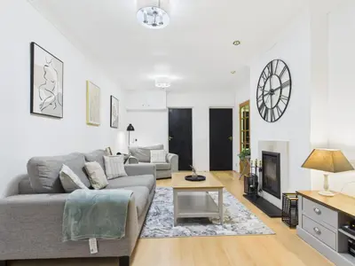 a living room with a couch and a table at Riviera Cottage - Cornwall in Portreath