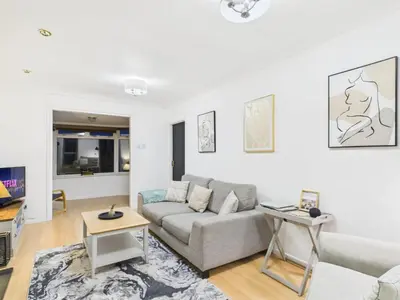 a living room with a couch and a tv at Riviera Cottage - Cornwall in Portreath
