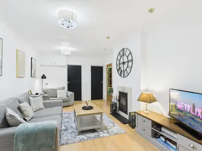 a living room with a couch and a tv at Riviera Cottage - Cornwall in Portreath