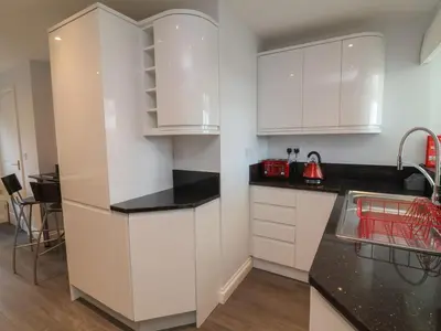 a kitchen with white cabinets and a sink at Atlantic View in Bude