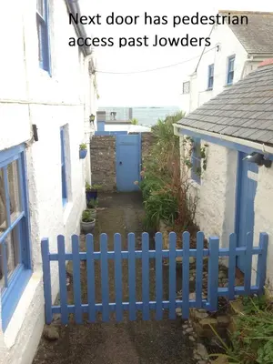 a blue fence in front of a house at Jowders Cottage in Marazion