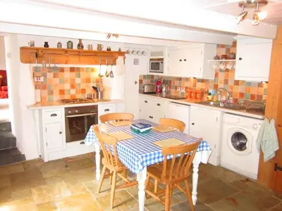 a kitchen with a table and chairs in it at Jowders Cottage in Marazion