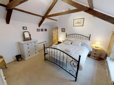 a bedroom with a large bed in a attic at Jowders Cottage in Marazion