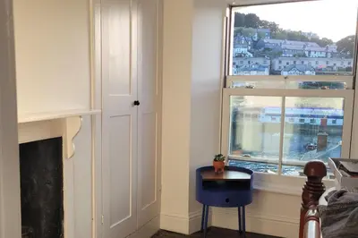 a room with a window and a table and a chair at Looe Cottage - Seaside views log fire sleeps 4 in Looe