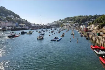 a group of boats are docked in a river at Looe Cottage - Seaside views log fire sleeps 4 in Looe