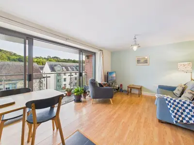 a living room with a table and chairs and a large window at Penryn Quayside Apartment – 1-bed, Fully Equipped Waterside base in Penryn