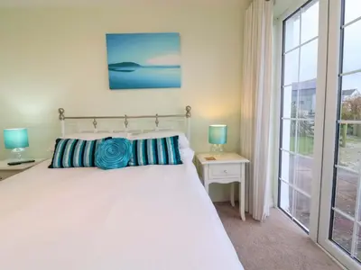 a bedroom with a bed and a large window at Atlantic View Annex in Bude