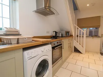 a kitchen with a washer and dryer in it at Atlantic View Annex in Bude