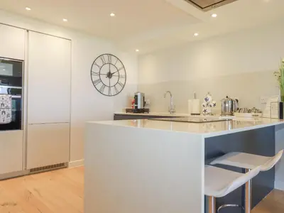 a kitchen with a counter and a clock on the wall at Beach View Fistral in Newquay