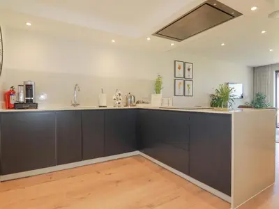 a kitchen with black cabinets and a counter top at Beach View Fistral in Newquay