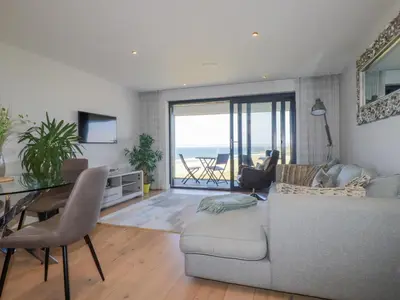 a living room with a couch and a table at Beach View Fistral in Newquay